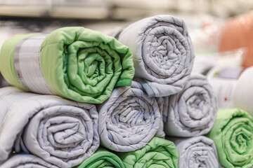 Obraz premium Rolled Green and Gray Padded Textiles in a Home Improvement Store