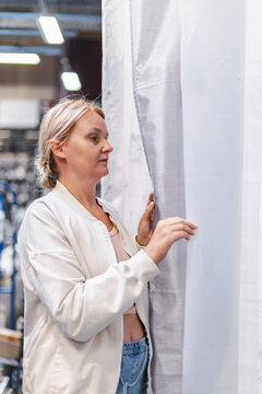 Woman Examining Sheer Curtains in Home Improvement Store