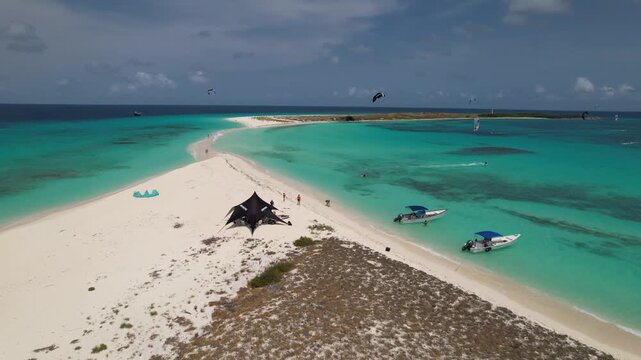 Aerial view of Los Roques archipelago with turquoise waters, white sandbars, boats, and kite surfers in Los Roques, Dependencias Federale, Venezuela.
