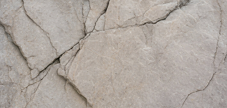 close-up of cracked gray stone surface, highlighting texture and natural patterns, ideal for backgrounds or architectural designs.
