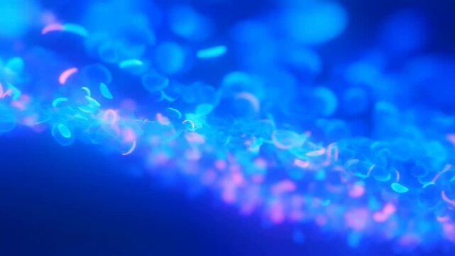 Cyan and Pink Light Particles Drift Through Soft Focus Against a Deep Blue Abstract Background