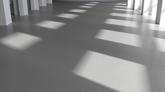 Sunlight and geometric shadows extend across an empty modern concrete hall