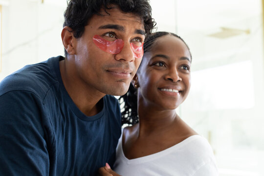 African American couple standing at home, man wearing navy shirt and pink eye patches