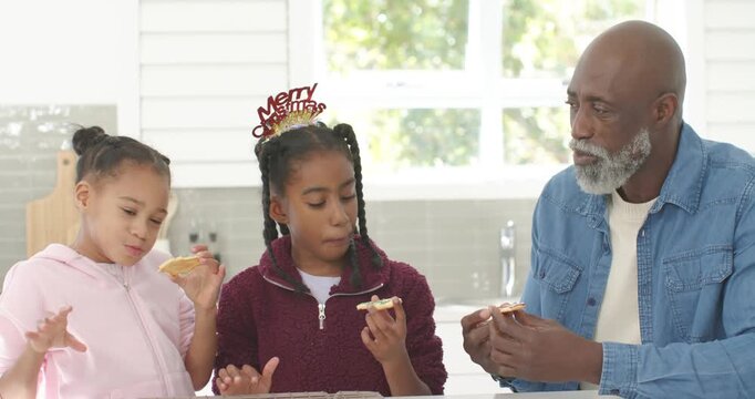 African American family tasting cookies at counter after seeing cooling rack and christmas headband