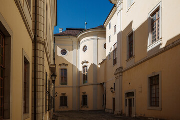 Exterior perspective shot looking into a shaded courtyard corner featuring a curved central tower facade and wall-mounted lanterns at Ludwigsburg Residential Palace in Ludwigsburg, Germany © Peeradontax