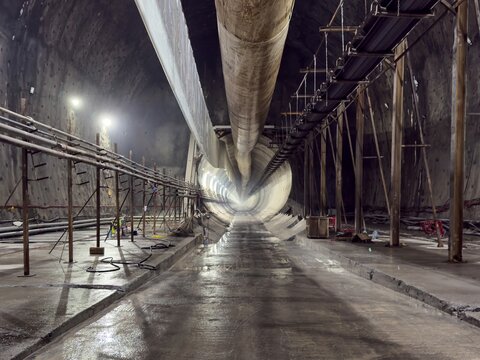 View of a large underground tunnel under construction with industrial pipes, support structures, and concrete walls, Istanbul, Istanbul, Turkiye.