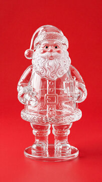 transparent glass santa claus holding gift on red christmas background as vertical wallpaper