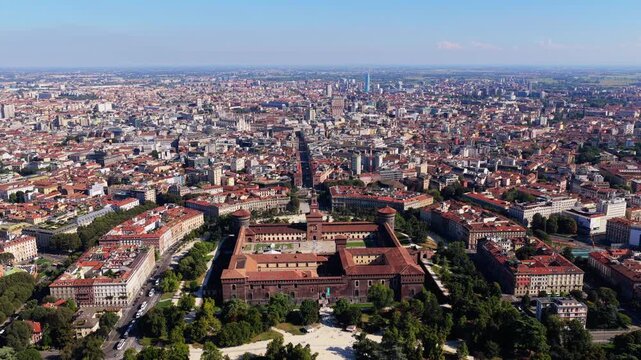 Wide aerial panorama of Castello Sforzesco in Milan, Italy, Via Dante, Milan Cathedral and Torre Velasca beyond, city spreading to hazy horizon on a sunny day