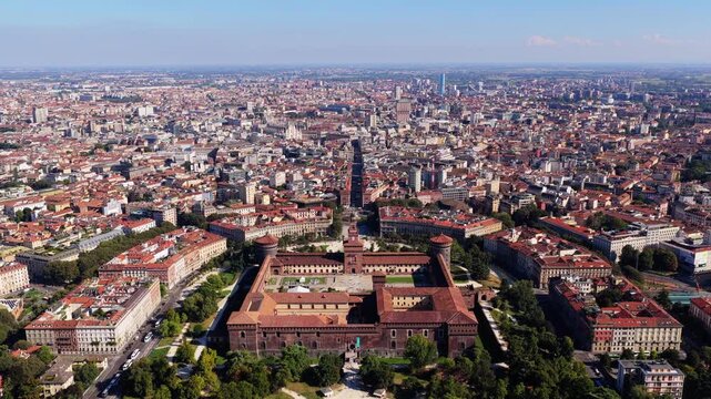 Forward flight from Parco Sempione toward Castello Sforzesco and its courtyards in Milan, Italy, Via Dante leading to Milan Cathedral and Torre Velasca on a sunny day