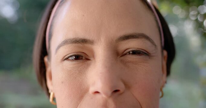 African American woman squinting closing opening eyes at window from sun pink headband gold hoops