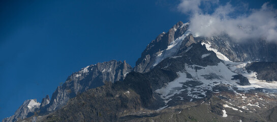 Obraz premium Summer view of the Mont Blanc massif above forested slopes 