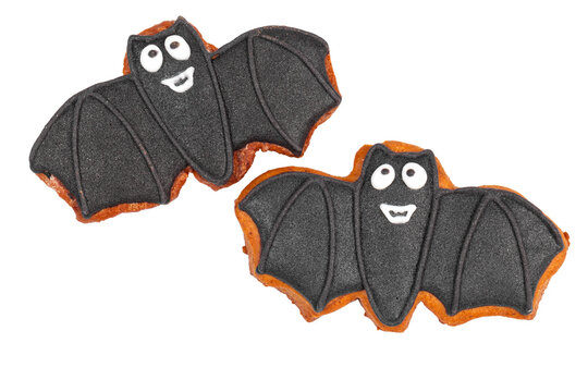 Halloween bat cookies shaped like bats with smiling faces on a white background