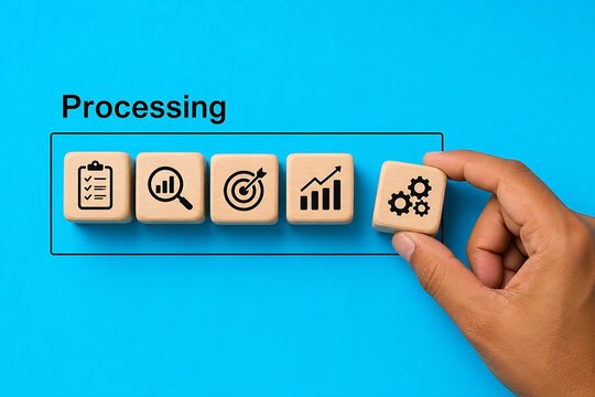 Hand touching wooden block with gear icon in processing workflow on blue surface