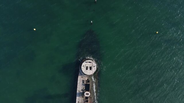 Top down aerial reveal shot flying backward over HMVS Cerberus historic shipwreck in ocean waters.