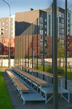 Empty outdoor bleachers next to a sports court in a modern residential area