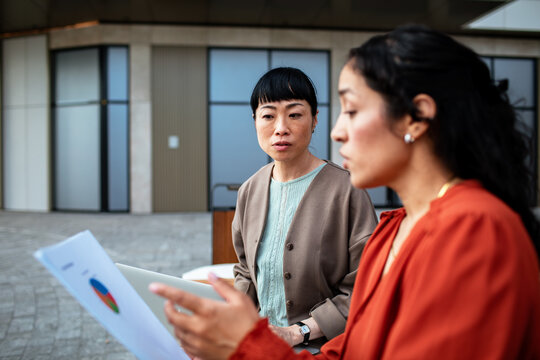 Two colleagues reviewing a printed chart outdoors