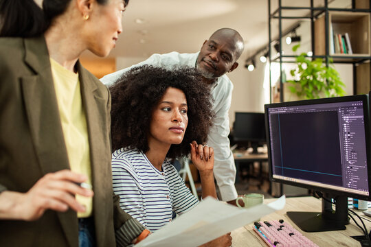 Coworkers reviewing design on office computer