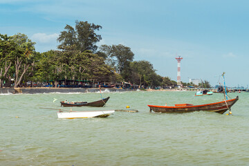 Small Wooden Fishing Boats Floating in Emerald Sea Near Coastal Village © k33pcalmncapture