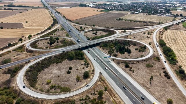 Aerial view of the cloverleaf Trakiya Highway interchange surrounded by agricultural fields in Bulgaria.