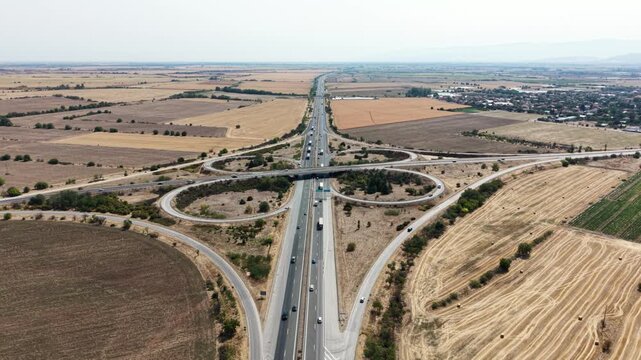 Aerial view of Trakiya Highway interchange surrounded by agricultural fields and rural landscape in Bulgaria.
