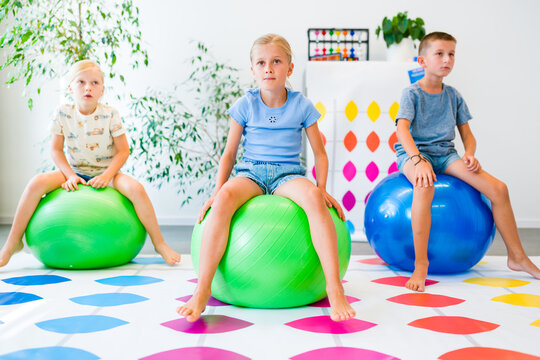 Kids practice balance, coordination and motor skills on exercise balls during an occupational therapy activity.