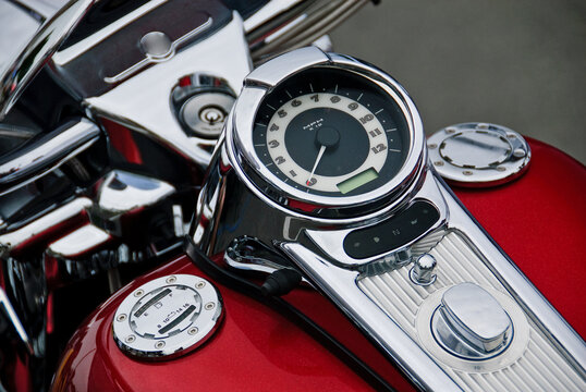 View of the chrome speedometer and fuel tank of a red motorcycle, Canada.