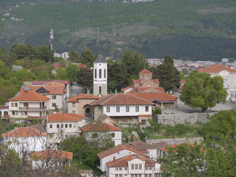 View of the Church of the Virgin Mary Peribleptos with its bell tower and terracotta roofs, surrounded by historic houses and trees in Ohrid, Municipality of Ohrid, North Macedonia.
