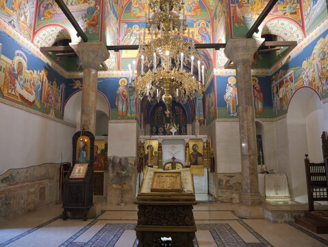 View of the interior of the Church of Saints Clement of Ohrid and Panteleimon with ornate frescoes, a large chandelier, and stone columns in Ohrid, Municipality of Ohrid, North Macedonia.