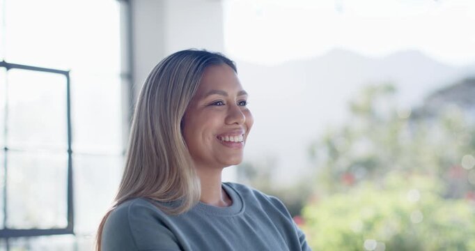 Woman in light-blue sweatshirt sitting arms folded by grid window hearing off-camera comment