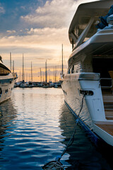 Fototapeta premium Vertical view of modern luxury motor yacht stern moored at a marina pier