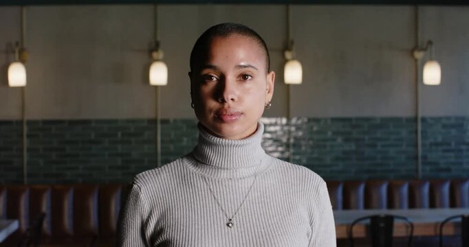 African American woman after camera prompt smiling then laughing in turtleneck at cafe with lights