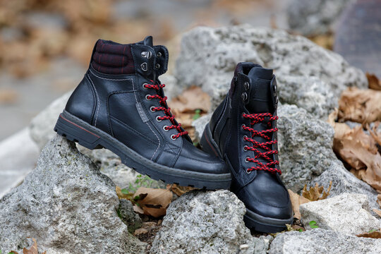 Pair of stylish black men's leather winter boots. Rugged ankle combat boots with laces for outdoor work or casual fashion