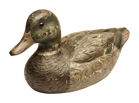 Vintage wooden duck decoy with aged green and brown paint isolated on white background.