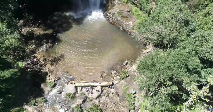 Aerial view of Cepe river with rocky banks and lush vegetation with people relaxing by the water in Maracay, Aragua, Venezuela.