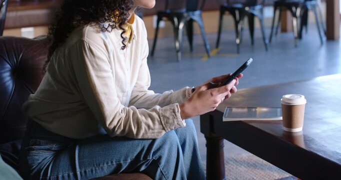Adult African American woman scrolling messages with tablet and cup, camera pulling back in cafe
