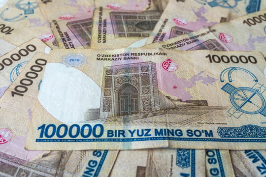 Pile of worn, scattered 100000 Uzbek som bills