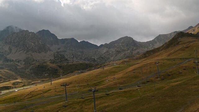 Timelapse of ski lift towers on alpine slope with dramatic overcast sky and peaks in Arcal&iacute;s, Ordino, Principality of Andorra, dramatic Pyrenean landscape.