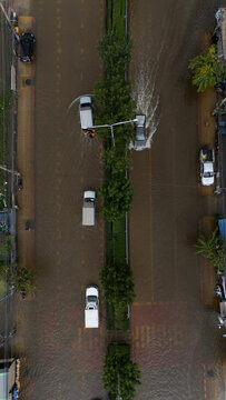 An elevated view of a flooded road with vehicles driving through the water.
