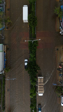 An elevated view of a flooded road with vehicles driving through the water.