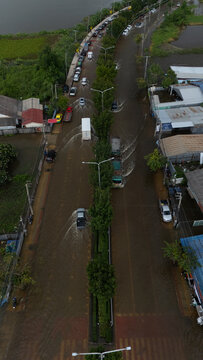 An elevated view of a flooded road with vehicles driving through the water.