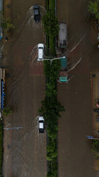 An elevated view of a flooded road with vehicles driving through the water.