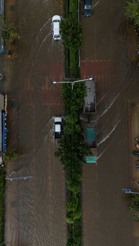 An elevated view of a flooded road with vehicles driving through the water.