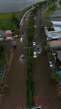 An elevated view of a flooded road with vehicles driving through the water.