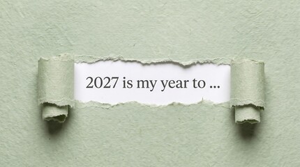 Fototapeta premium Torn green paper revealing the text 2027 is my year to, new year goals, resolutions and motivation concept for planning, personal growth, success and a fresh start in the new year