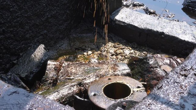 Traditional crude oil extraction from deep well at Teksas Wonocolo mining field in Bojonegoro, East Java, Indonesia. Raw black petroleum pulling process using traditional pipe rig in a rural area.