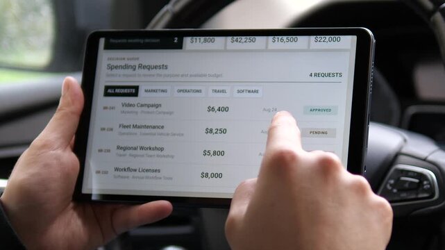 Business manager reviews company spending requests on a tablet, comparing department budgets and approval status to control costs and prioritize corporate investments.