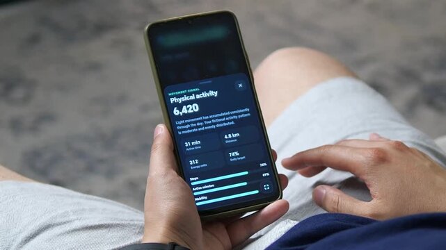 Person reviews daily activity metrics on a smartphone, highlighting fitness tracking, movement goals and the growing role of digital tools in preventive health.