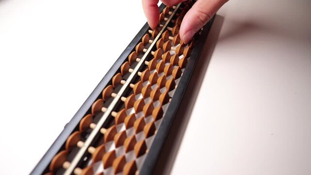 Slow-motion fingers calculating on an abacus.