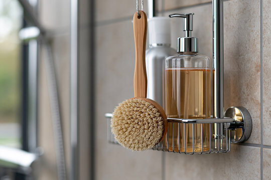 Shower caddy holding essential body care products, featuring an eco friendly wooden brush and liquid soap dispenser, promoting daily hygiene and self care
