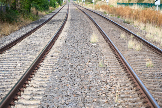 Railway tracks converge toward a distant horizon
